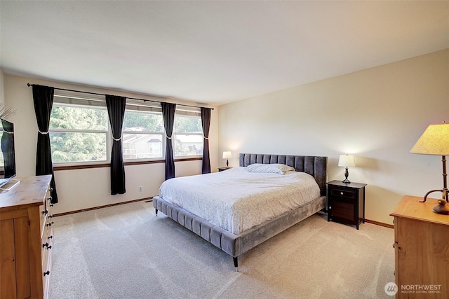 bedroom featuring baseboards and light carpet