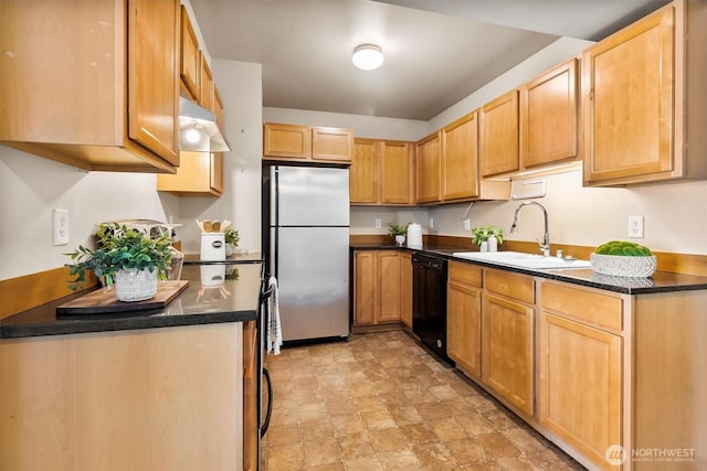 kitchen with stone finish flooring, a sink, freestanding refrigerator, light brown cabinets, and black dishwasher