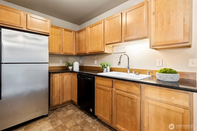 kitchen featuring freestanding refrigerator, light brown cabinetry, black dishwasher, stone finish floor, and a sink