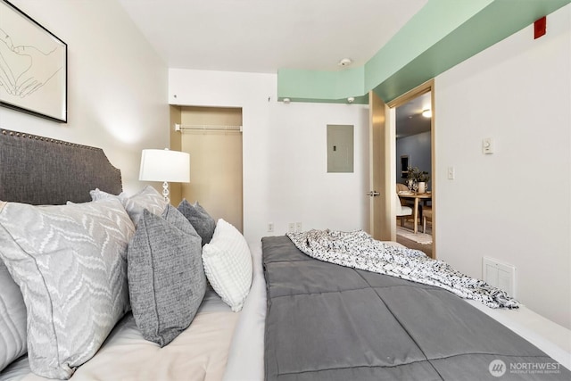 bedroom featuring electric panel, a closet, and visible vents