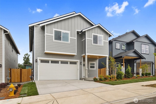 view of front of property with a garage, fence, board and batten siding, and driveway