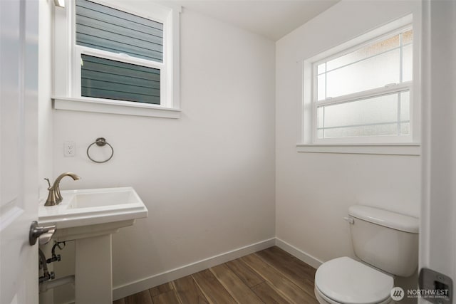 bathroom with wood finished floors, toilet, and baseboards