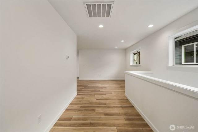 hall featuring visible vents, recessed lighting, light wood-style flooring, and baseboards