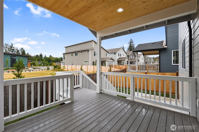 wooden terrace with a residential view and fence