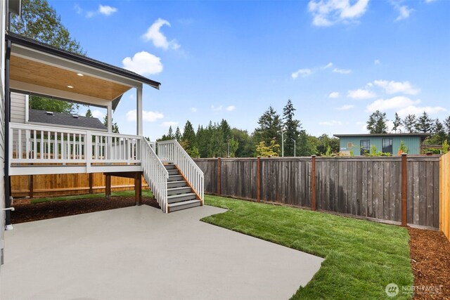 view of yard featuring a deck, stairs, a fenced backyard, and a patio area