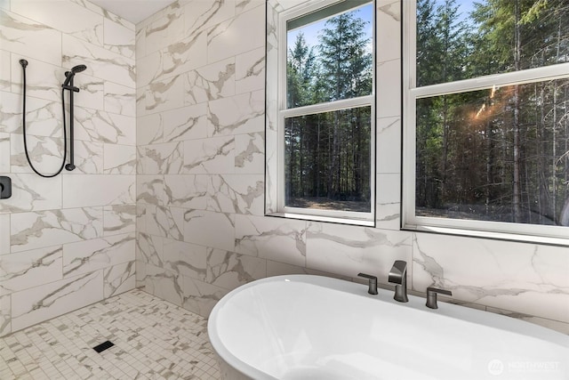 bathroom featuring a freestanding bath, tile walls, and tiled shower