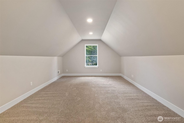 additional living space with lofted ceiling, baseboards, carpet floors, and visible vents