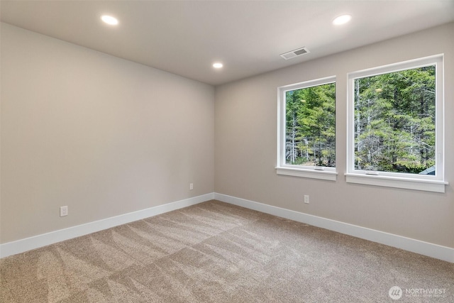 unfurnished room with recessed lighting, visible vents, baseboards, and light carpet