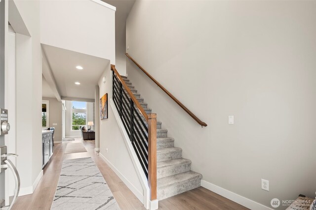 stairs featuring baseboards, recessed lighting, and wood finished floors