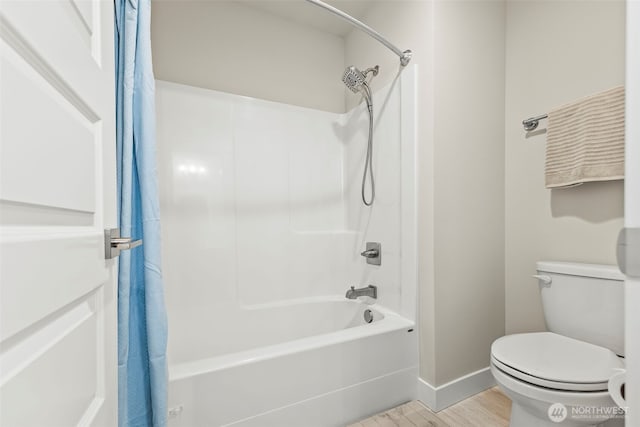 full bathroom featuring toilet, baseboards, wood finished floors, and shower / bath combo