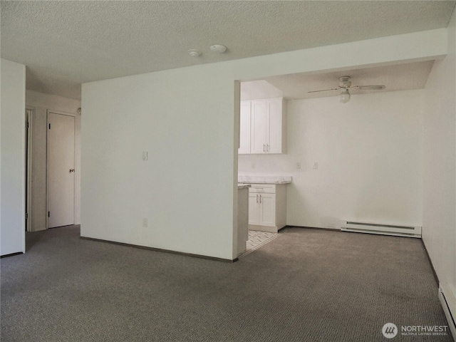 interior space featuring carpet, baseboards, baseboard heating, and a ceiling fan