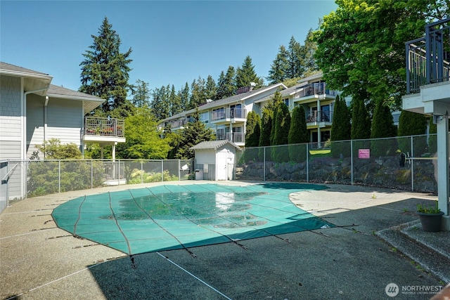 community pool with fence and a patio area