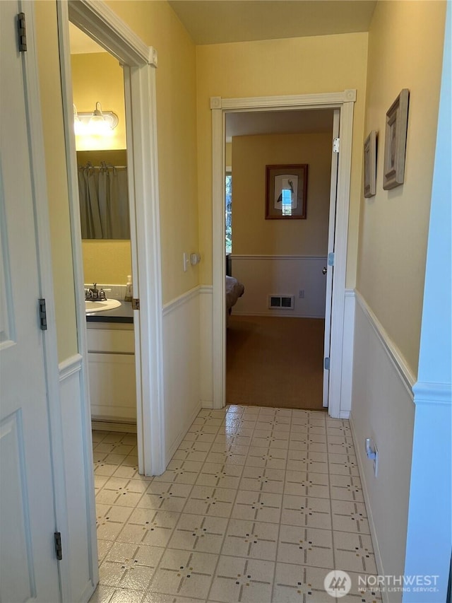 20713 Pacific Way Unit 4, Ocean Park, WA 98640 - corridor featuring wainscoting, a sink, and light flooring