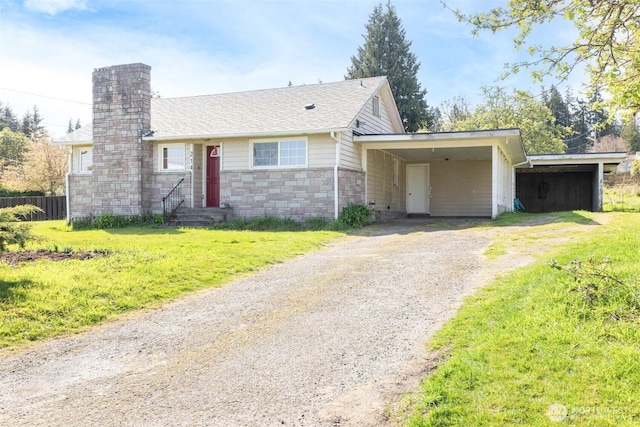 single story home with a chimney, a carport, driveway, stone siding, and a front lawn