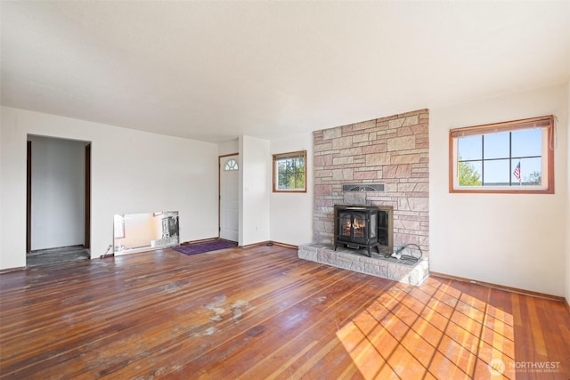 unfurnished living room featuring hardwood / wood-style flooring and baseboards