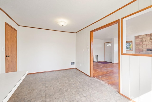 spare room with visible vents, ornamental molding, and baseboards