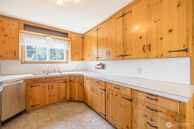 kitchen featuring dishwasher, light countertops, and a sink