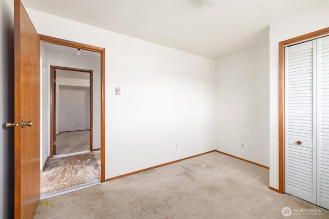 unfurnished bedroom with carpet, baseboards, and a closet
