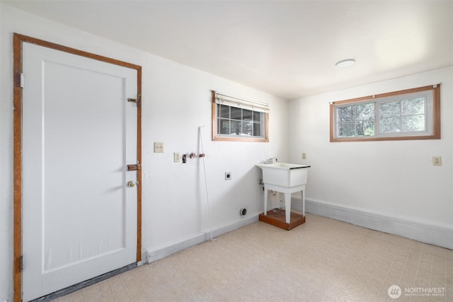 washroom with electric dryer hookup, baseboards, tile patterned floors, and laundry area