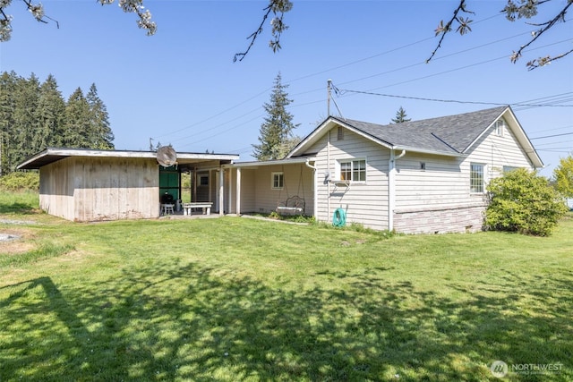 back of property with a yard and roof with shingles