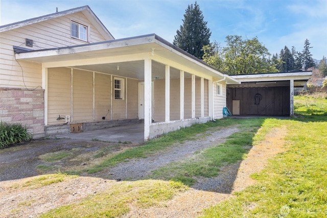view of side of property featuring driveway and an attached carport