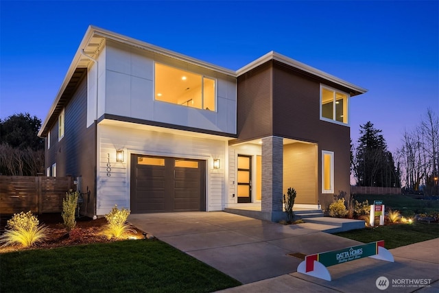 contemporary house featuring fence, concrete driveway, and an attached garage