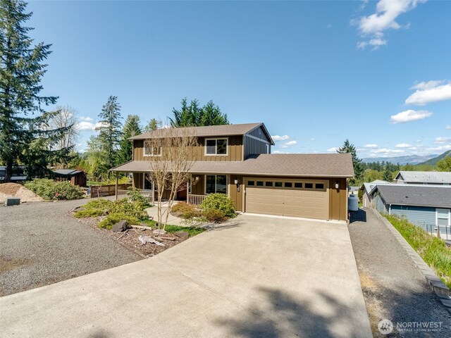 traditional home with a garage, a porch, board and batten siding, and driveway
