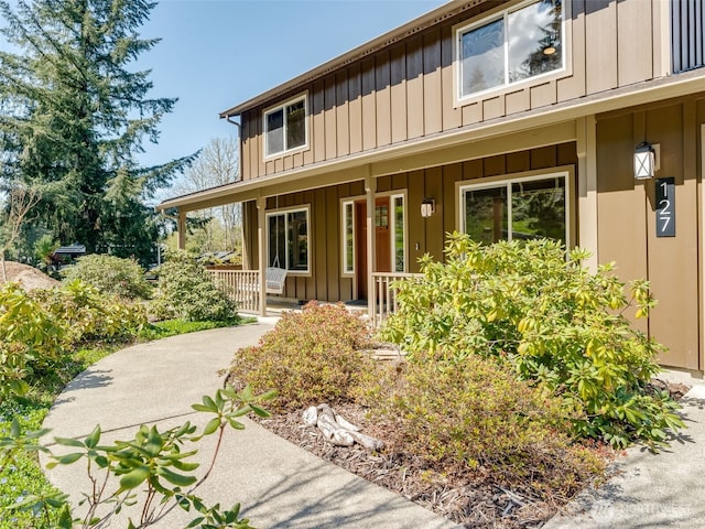 doorway to property with a porch and board and batten siding