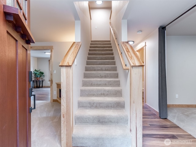staircase featuring carpet flooring and baseboards