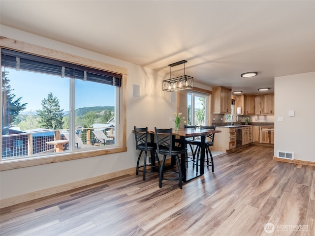 dining area with visible vents and light wood-style floors