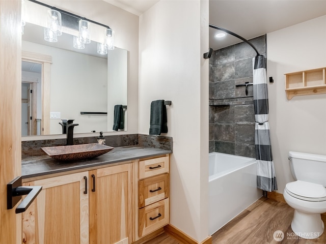 full bath with toilet, vanity, shower / bath combination with curtain, and wood finished floors