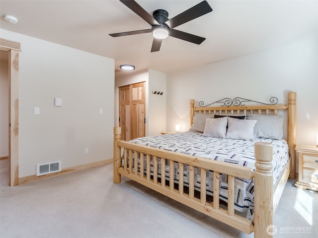 carpeted bedroom with visible vents, ceiling fan, and baseboards