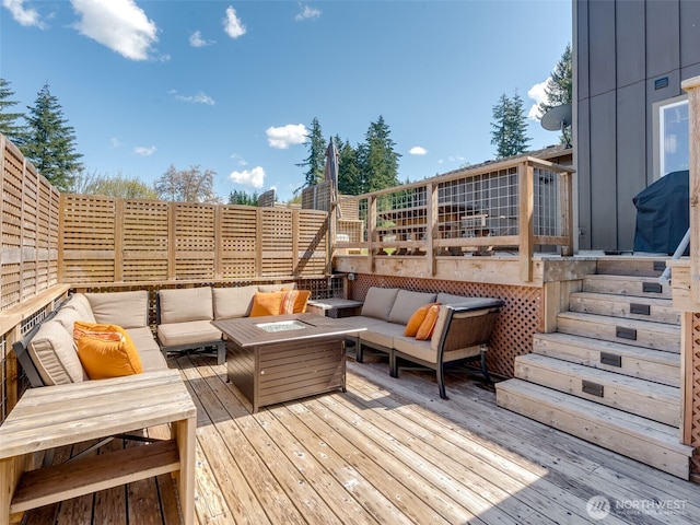 deck featuring an outdoor living space with a fire pit