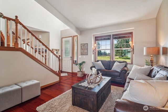 living area with dark wood-type flooring, stairway, and baseboards