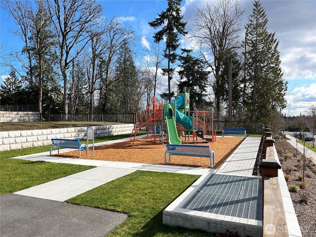community jungle gym featuring a lawn and fence