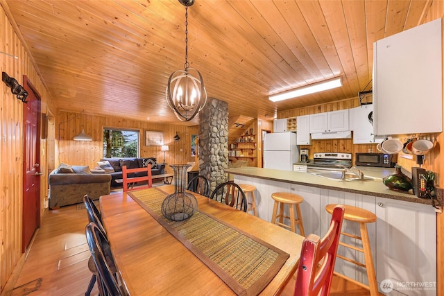 18016 Glacier Rim Dr, Glacier, WA 98244 - dining area featuring wooden ceiling, an inviting chandelier, decorative columns, light wood-style floors, and wooden walls