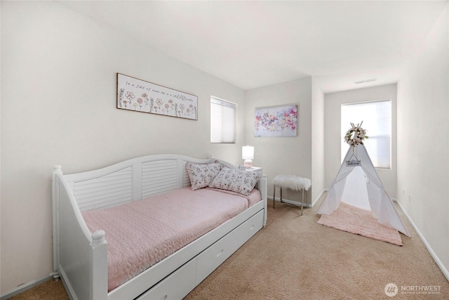 carpeted bedroom with visible vents, baseboards, and multiple windows