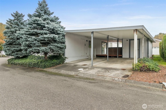 exterior space featuring concrete driveway and an attached carport