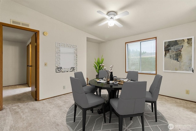 dining area featuring lofted ceiling, visible vents, ceiling fan, and light carpet