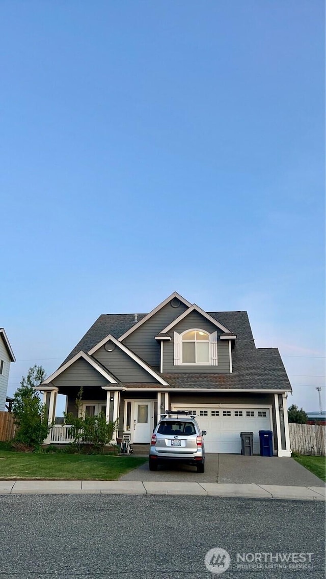 view of front of house featuring a porch, roof with shingles, a garage, fence, and concrete driveway