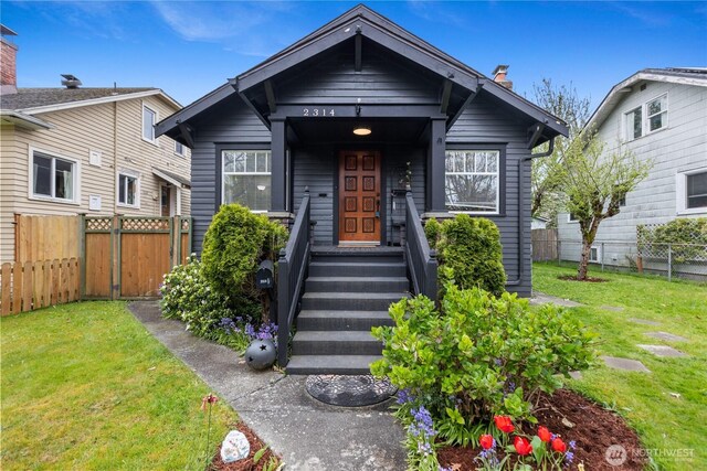 view of front of property with fence, a chimney, and a front yard