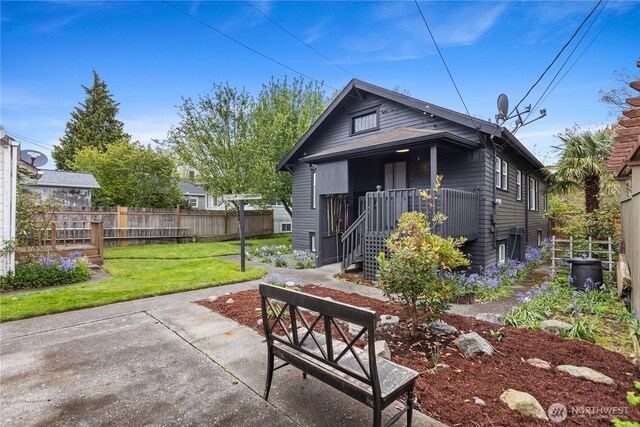 rear view of house with a patio, fence, and a yard