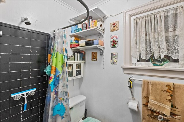 bathroom featuring toilet and curtained shower