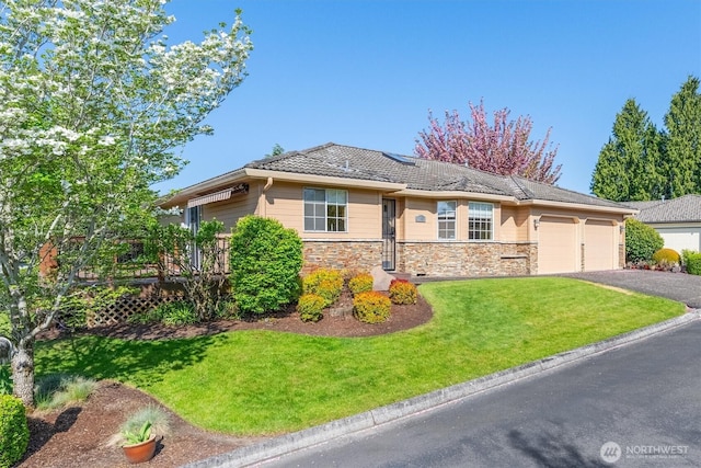 single story home with a garage, a wooden deck, driveway, stone siding, and a front yard