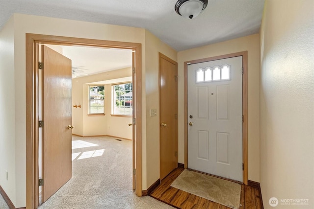 doorway to outside with baseboards, light carpet, and plenty of natural light