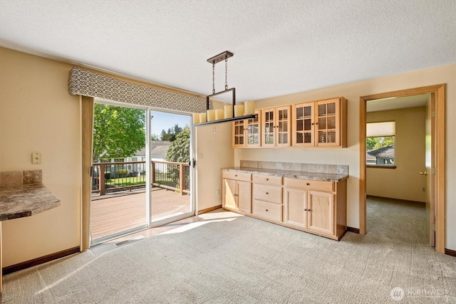 kitchen featuring light brown cabinetry, a wealth of natural light, and light colored carpet
