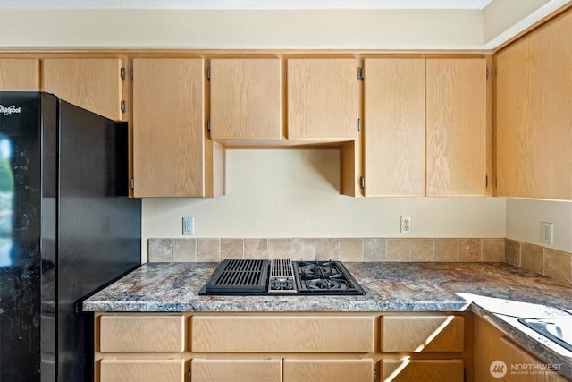 kitchen with light brown cabinets, stovetop with downdraft, and freestanding refrigerator