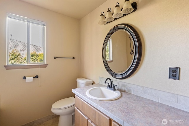 bathroom featuring a wealth of natural light, toilet, tile patterned flooring, and vanity
