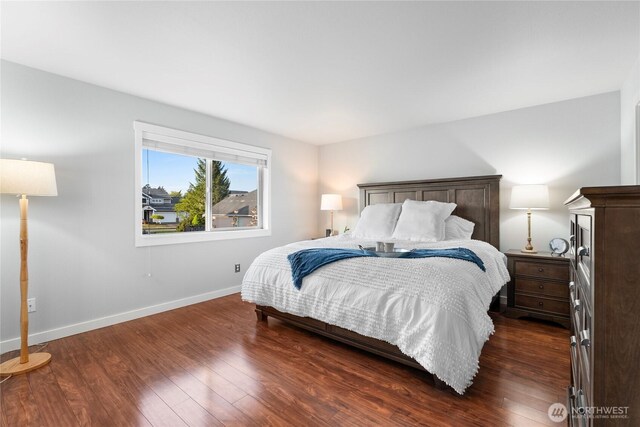 bedroom featuring baseboards and dark wood-style flooring