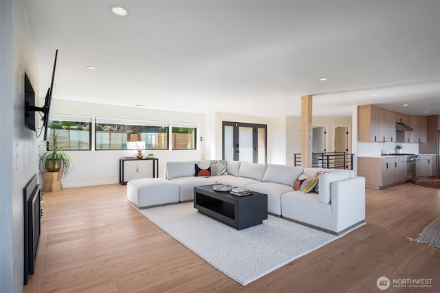 living room featuring light wood-style floors, recessed lighting, and baseboards